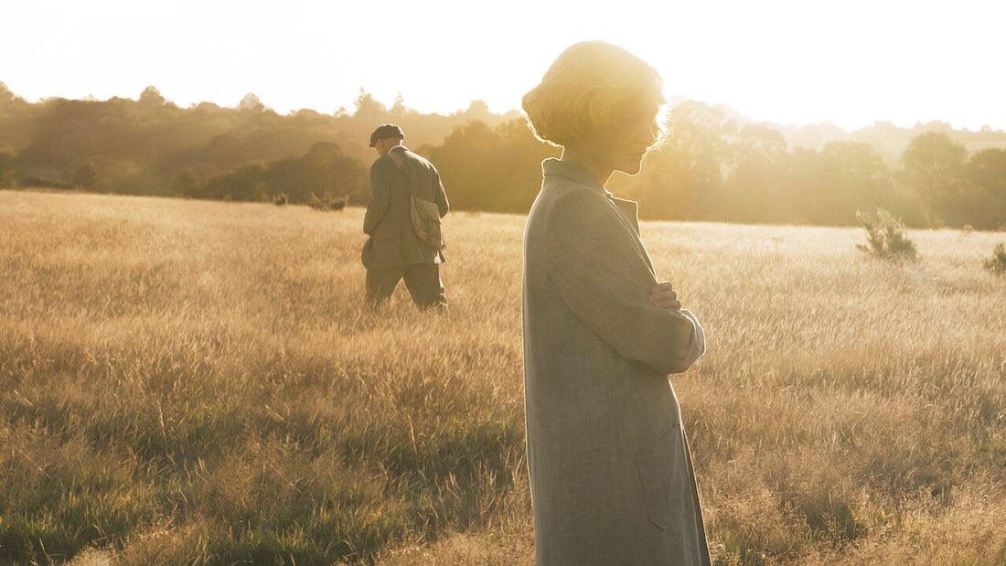 A woman and a man in the distance in a field at sunset