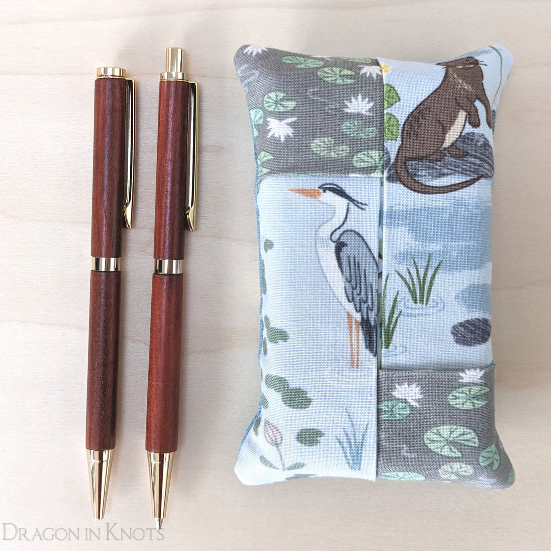 wooden pen and pencil next to a pocket tissue holder with a nature theme